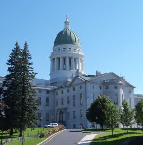 View of Maine State House building and dome on a sunny day with blue sky in background
