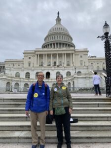Two people standing on the steps of the US Capitol